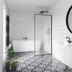 a bathroom with black and white tile flooring and walls, along with a bathtub