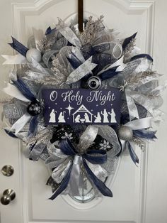 a christmas wreath on the front door with an ornament and nativity message