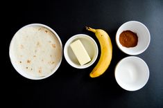 three bowls with different types of food in them on a black surface next to a banana