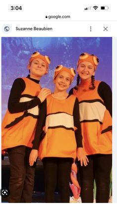 three girls in orange and black costumes standing next to each other with their hands on their hips