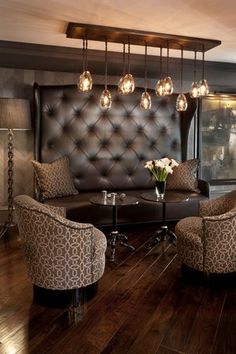 a living room filled with lots of furniture next to a wall mounted tv on top of a wooden floor