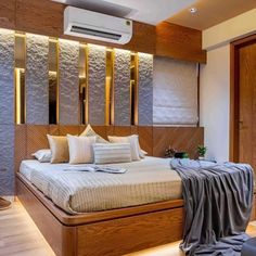 a large bed sitting in the middle of a bedroom next to a wall mounted air conditioner