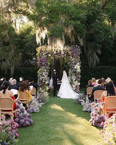 a bride and groom standing at the end of their wedding ceremony in front of an archway decorated with flowers