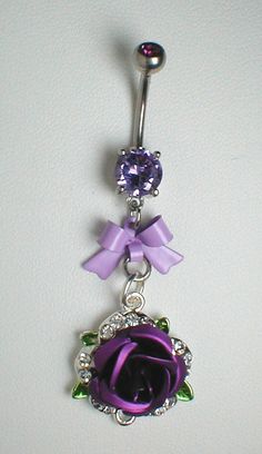 a purple rose is attached to a navel bar