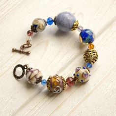 "This Lavender boho bracelet bracelet is a perfect gift for women. It's very tender and unique! This lampwork bracelet fits a 15.5-16.5cm (6.1\"-6.5\" inch) diameter wrist. If you need bigger or smaller size bracelet, please, write me the diameter of your wrist when making an order. Dimentions: 21cm. Materials: artist lampwork beads, metal and glass beads, metal fittings. Colors used: blue, lavender, lilac. Please, note, each lampwork bead is made by hand and may differ slightly. All the photos Bohemian Beaded Bracelets With Round Beads As Gifts, Adjustable Bohemian Crystal Bracelet With Large Beads, Adjustable Bohemian Czech Glass Beaded Bracelets, Bohemian Bracelets With Spacer Beads For Gift, Bohemian Bracelets With Spacer Beads As Gift, Bohemian Crystal Bracelet With Large Beads For Gift, Bohemian Beaded Bracelets With Faceted Beads For Jewelry Making, Bohemian Czech Glass Bracelets With Large Beads, Bohemian Bracelet With Faceted Beads