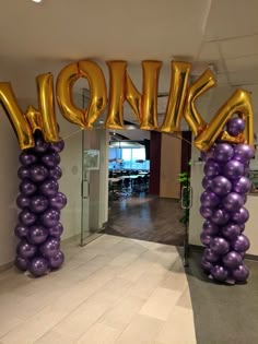 an entrance decorated with balloons that spell out the word kohle in gold and purple