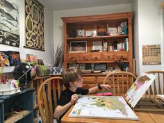 a young boy sitting at a table with a map on it