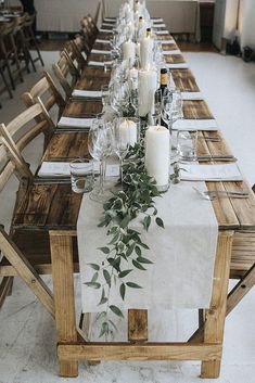 a long table is set with candles and greenery for an elegant dinner or party