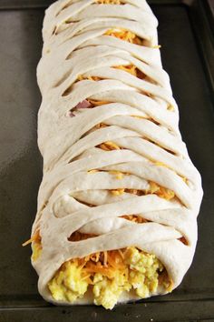 an uncooked burrito sitting on top of a baking pan covered in white frosting