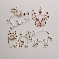 four different animal shaped brooches on a white surface