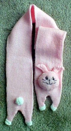 two pink baby mittens laying on top of a green carpet next to each other