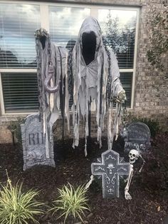 halloween decorations in front of a house with fake skeletons and tombstones on the ground