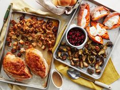 two trays filled with chicken, potatoes and cranberries next to each other