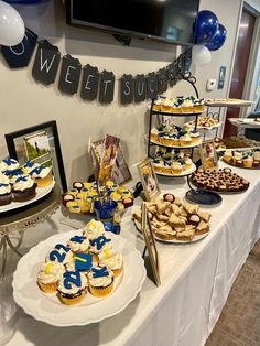 a table topped with lots of cupcakes and cakes