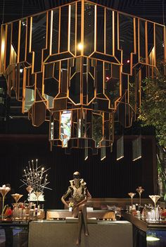 a chandelier hanging from the ceiling above a bar with various items on it