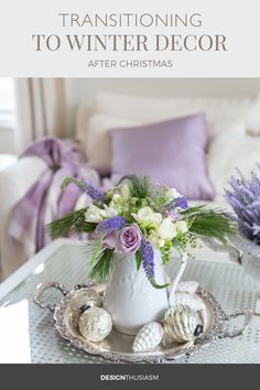 a white vase filled with flowers sitting on top of a table next to a couch