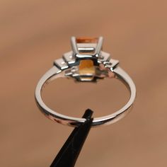 It is a natural citrine ring. The main stone is 6 mm*8 mm emerald cut.weight about 1.43 carats. The basic metal is sterling silver and plated with rhodium. To change the metal to a solid gold (white/rose) or platinum is also available, please ask for a quotation if you want. You can also go to my shop Home for more elegant rings: https://www.etsy.com/shop/godjewelry?ref=hdr_shop_menu More citrine rings: https://www.etsy.com/shop/godjewelry?ref=seller-platform-mcnav&search_query=citrine Custo Citrine Gemstone Rings In Baguette Cut, Octagon Citrine Gemstone Ring, Citrine Baguette Cut Ring For Anniversary, Yellow Topaz Emerald-cut Ring In Fine Jewelry, Yellow Emerald Cut Topaz Ring In Fine Jewelry Style, Yellow Emerald-cut Topaz Ring Fine Jewelry, Yellow Emerald-cut Topaz Ring, Emerald Cut Topaz Rings In Fine Jewelry Style, Topaz Octagon Ring For Anniversary