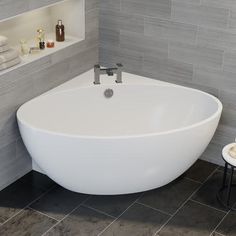 a white bath tub sitting on top of a tiled floor next to a shelf filled with bottles