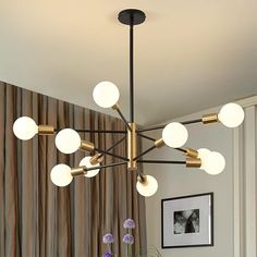 a modern chandelier hangs over a dining room table with flowers in vases