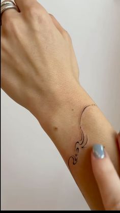 a woman's hand with a small tattoo on her wrist