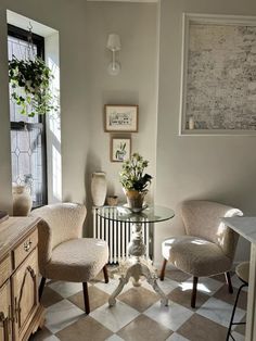 two chairs and a table in a room with checkered flooring on the floor