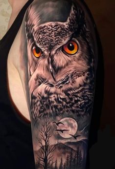 an owl with orange eyes is shown on the upper half of this arm tattoo design