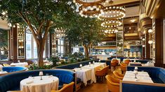 a restaurant with tables, chairs and chandeliers