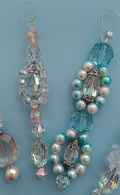 three necklaces with pearls and crystal beads on a blue background, one is hanging from the side