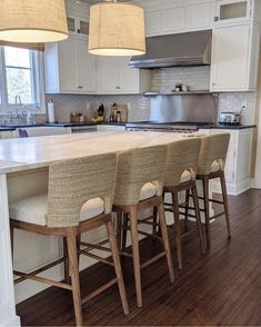 a kitchen island with four stools in front of it