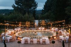 an outdoor dining area with tables, chairs and candles lit up at night in the evening