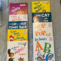 three children's books laying on top of a bed