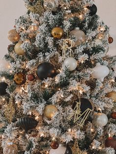 a decorated christmas tree with gold, white and black ornaments