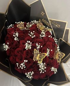 a bouquet of red roses with butterfly brooches and pearls in the shape of a heart