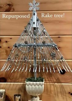 a christmas tree made out of nails on top of a potted plant with the words repupposed rake tree above it