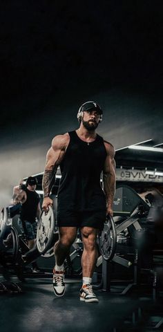 a man in black shirt and shorts holding a barbell