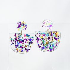 Festive glitter Mardi Gras. These light weight earrings feature colorful glitter set in a clear resin, making them a perfect match to any carnival attire. Made in New Orleans. Measures approximately 1.5 IN wide x 1.75 IN tall. Earring post stud is stainless steel. This listing is for ONE pair of earrings. See all of the jewelry we carry online HERE. Multicolor Plastic Jewelry For Party, Plastic Round Jewelry For Parties, Handmade Clear Plastic Earrings, Round Plastic Party Jewelry, Colorful Plastic Jewelry For Party, Fun Plastic Jewelry For Party, Multicolor Resin Jewelry For Party, Plastic Drop Earrings For Party, Iridescent Glitter Earrings For Party