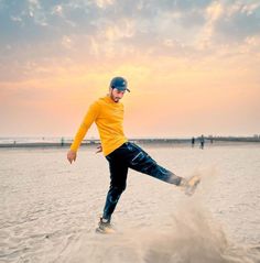 a man is kicking sand on the beach