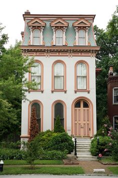 a large white house with pink trim and arched windows