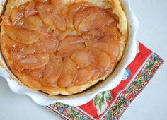 a pie sitting on top of a white plate next to a red and blue napkin