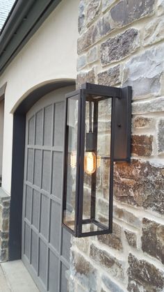 a light that is attached to the side of a brick wall next to a door