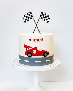 a birthday cake decorated with a race car and checkered flag on the top tier