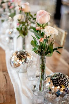 there are many vases on the table with flowers in them and disco ball decorations