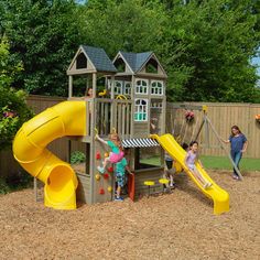 children playing in a backyard with a yellow slide and play set on top of it