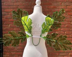 a white mannequin with green leaves on it