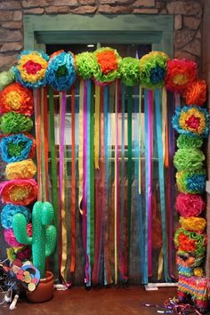 colorful streamers and flowers decorate the entrance to a room with cactus, cacti, and succulents