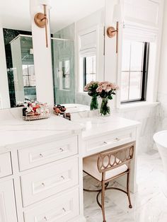 a bathroom with marble floors and white cabinets