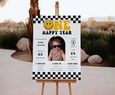 a one year old birthday party sign with a photo and checkerboard design on it