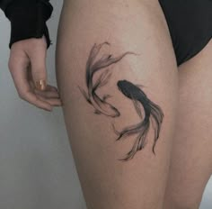 a woman's thigh with a tattoo of a goldfish