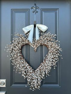 a heart shaped wreath is hanging on the front door