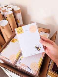 a person holding a piece of paper in front of a box full of sticky notes